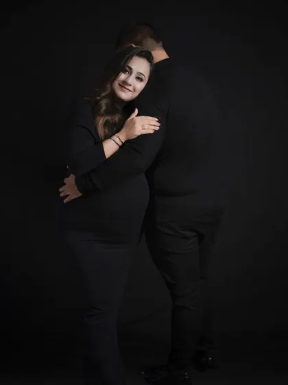 A classic back-to-back pose, with the expecting mother embracing her partner from behind.
