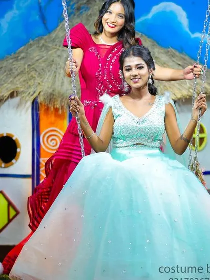 A fun and friendly photoshoot featuring two women in beautiful gowns on a swing set, perfect for capturing special moments with friends.
