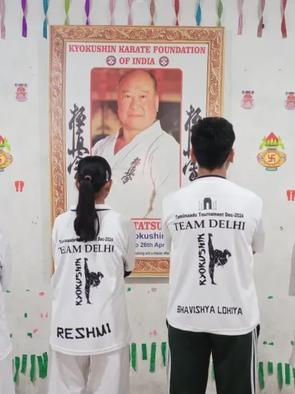 The team stands before the portrait of our founder, Sosai Masutatsu Oyama, showing respect before embarking on their journey.
