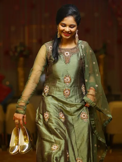 Sometimes the best moments happen after the formalities are over. This candid photo captures a guest or the bride in a different outfit, smiling as she carries her shoes after a long night of dancing. It’s a real, relatable moment that adds character to the wedding story.