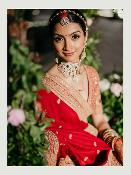Our radiant bride, framed by a lush floral backdrop. We work to ensure the decor complements the couple, making their moments in the mandap even more magical and picture-perfect.