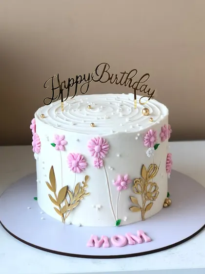 A dainty cake for Mom, with delicate pink flowers and golden leaves.