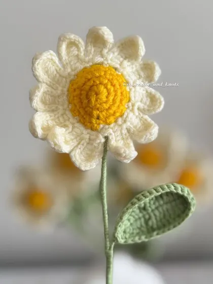 An up-close shot of a single daisy, showing the detail of each of the twelve crocheted petals. I love making these simple and happy flowers.