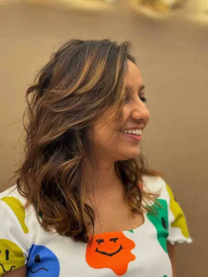 A happy client with her new highlights. The color adds a beautiful, natural-looking glow that brightens her entire look.