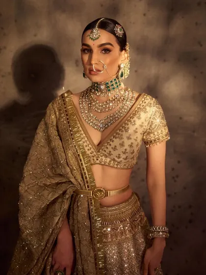 This powerful bridal look combines a deep V-neck blouse with bold, structured makeup. You'll learn how to create a defined jawline and cheekbones through advanced contouring techniques.