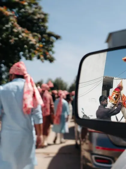 A creative reflection shot of the groom's baraat in a car's side mirror. We are always looking for artistic ways to document your day.