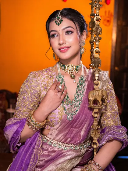 For this South Indian bridal look, we paired a modern lilac saree with traditional emerald jewelry. I focused on creating dewy, luminous skin and soft, defined eyes to achieve a look that felt both royal and effortlessly graceful.