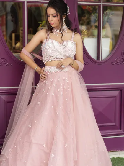 A perfect bridesmaid outfit in a soft pink, featuring a sequined blouse and a lightweight tulle skirt with star embellishments.