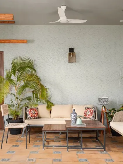 This semi-outdoor lounge at the Prakash Reddy residence is a perfect example of tropical modernism. Terracotta tiles, a comfortable swing, and abundant palm plants create a relaxed, resort-like feel.