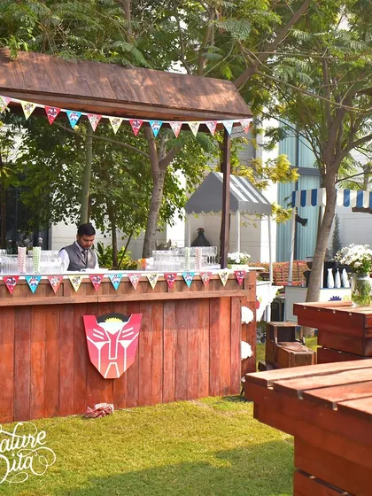 A rustic wooden bar decorated with a Transformers logo for the kids' party.