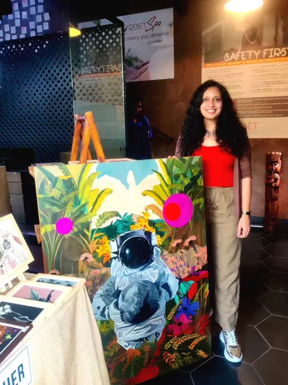 Me standing proudly next to my 'Recuperation' painting at a flea market in Bangalore. This artwork was used as a decor piece for my stall and ended up being the star of the show.