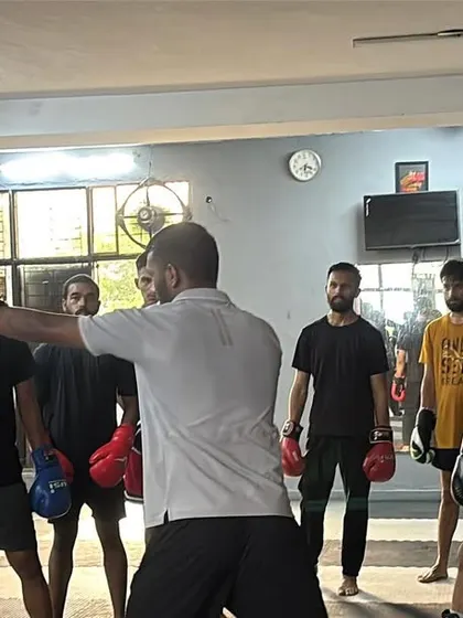 I'm demonstrating a defensive move to a group of attentive students. Clear instruction is key to their development.