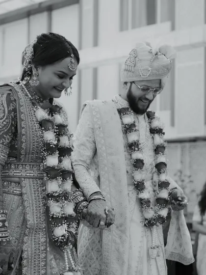 A happy moment of the bride and groom walking hand-in-hand after their ceremony. This black and white photo is full of joy and emotion.