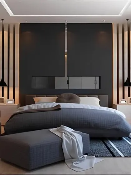 A modern bedroom with a bold, dark accent wall featuring vertical wood slats and integrated lighting. The room has a masculine feel, with framed black and white prints and a low-profile bed.