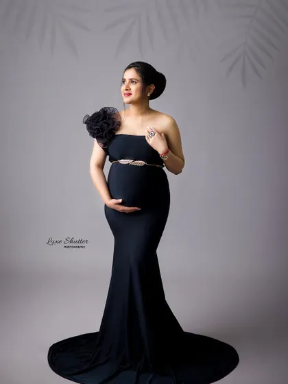 A classic and elegant pose in a timeless black gown. The floral shoulder detail and simple belt add just the right amount of texture and interest.