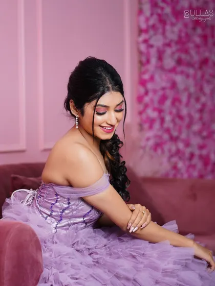A close-up of the lavender gown's off-shoulder design and detailed corset, taken on our pink sofa for a soft, feminine feel.