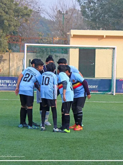 A team huddle before the action begins. I teach my players the importance of unity, strategy, and supporting each other, which are lessons that extend far beyond the football pitch.