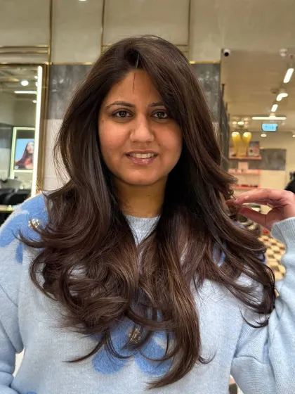 A happy client with her new mocha brown hair. The color is rich and flattering, and the layered cut gives it beautiful volume.