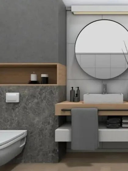 A minimalist bathroom design using a combination of grey stone tiles and wood accents. The floating vanity and simple round mirror create a clean, functional, and modern aesthetic.