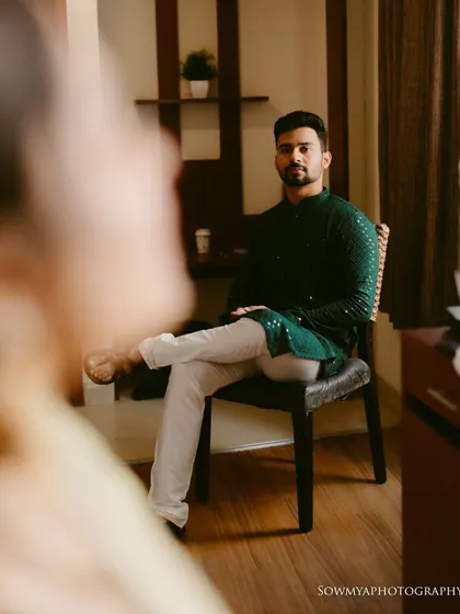 An over-the-shoulder shot of the groom during a pre-wedding session. The shallow depth of field creates a sense of intimacy and anticipation.