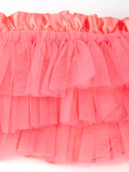 A macro shot of the layered tulle fabric on the coral skirt.