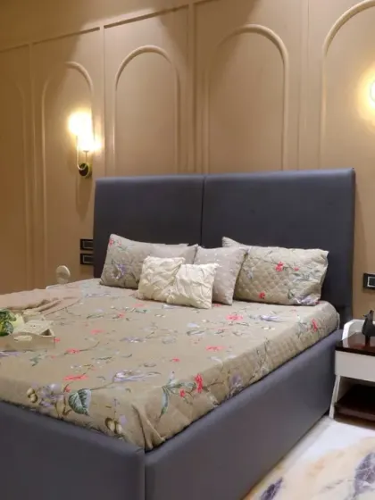 Another view of the guest bedroom, highlighting the layered window treatments and the warm, inviting color palette.