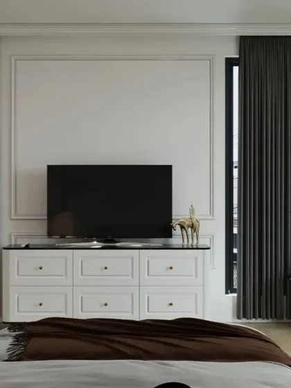 A minimalist approach to a bedroom TV unit, with a clean white console and classic wall moulding, creating an uncluttered and sophisticated look.