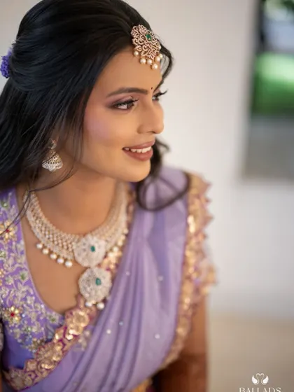 A profile shot of the bride, highlighting her makeup, hairstyle, and the intricate details of her blouse.