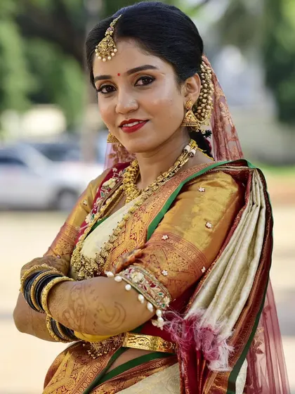 A confident pose from Sahana. This angle showcases the detailed eye makeup and how the complete look, including the hair and jewellery, comes together for a powerful bridal presence.