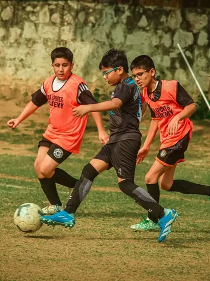 Three players from the same academy work together to win the ball.