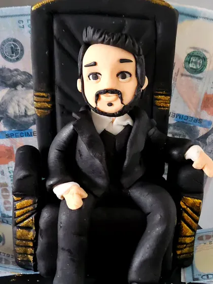 A close-up of the hand-sculpted figurine for "The World Is Yours" cake. You can see the details in the facial features and the texture of the suit, all crafted from fondant.