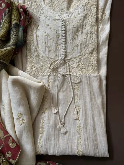 A close-up of the Anarkali's bodice, showcasing the intricate Chikankari, button details, and adjustable ties. The coordinated tissue chanderi dupatta is visible in the background.