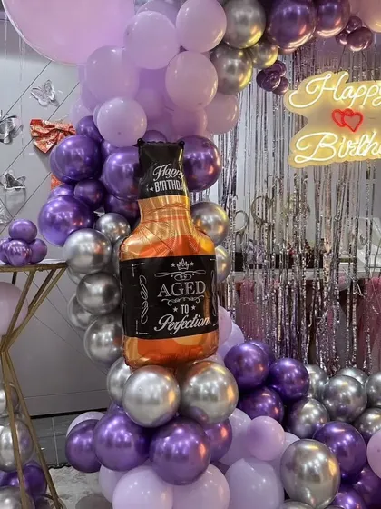 Yeh 40th birthday decoration ka ek aur angle hai. Isme aap "Happy Birthday" neon sign aur whiskey bottle balloon ko saaf dekh sakte hain.