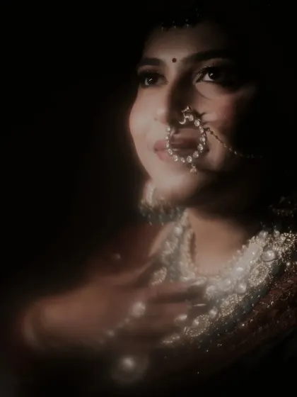 The shadows of trident in her eyes. A close-up, artistic portrait of the bride, with a soft, dreamy focus on her face and jewelry.