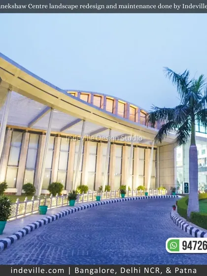 The main building of Manekshaw Centre at dusk, with the driveway lined with illuminated planters. This highlights my work in large-scale commercial lighting and landscape.