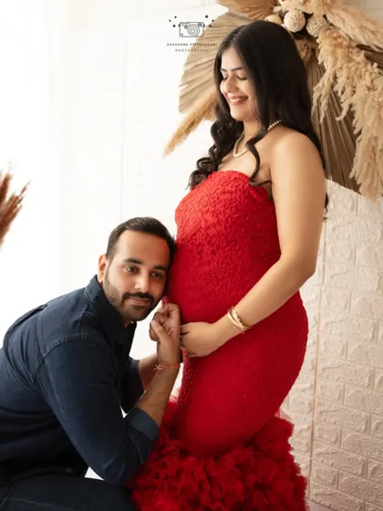 A playful and classic maternity pose. The father-to-be listens to the baby bump, a sweet and timeless moment to cherish forever.