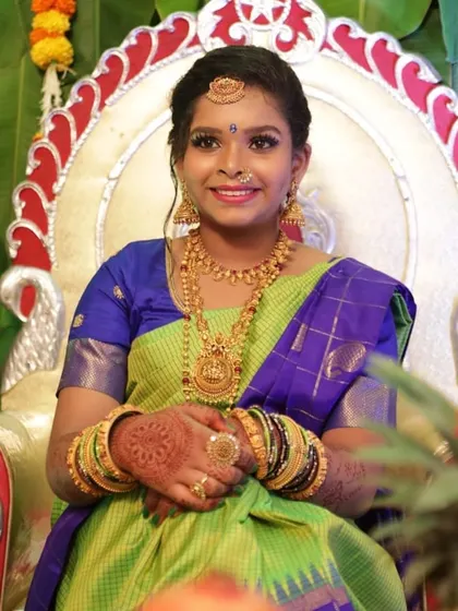A close-up of the half-saree function look. You can see the details of the henna, the traditional bangles, and the radiant smile of the happy client.