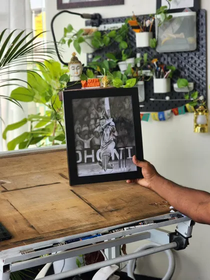 The framed Dhoni portrait on my drawing table, showing the final result of a challenging but enjoyable project.