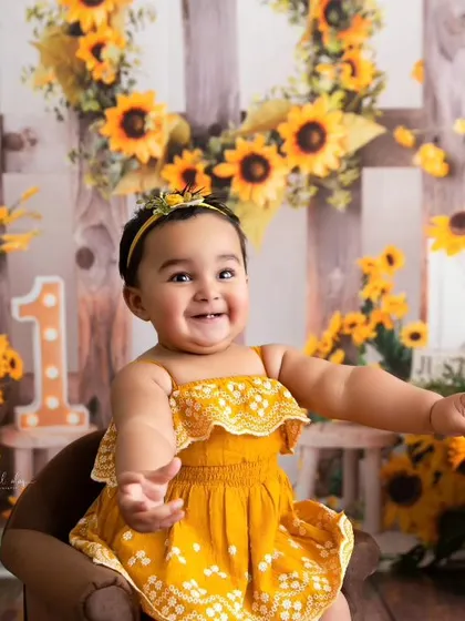 An open-armed, welcoming pose from the birthday girl in her sunny yellow dress.