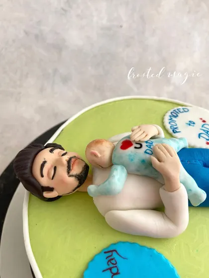 This cake topper was for a new dad's birthday, capturing that sweet, exhausting moment of bonding with a newborn. It’s these personal, relatable stories that I love to translate into sugar art.