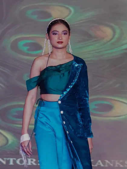A model showcases a stylish ensemble with a peacock-feather inspired theme.