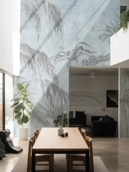 This wallpaper uses delicate, sweeping lines to suggest a breezy palm forest on a textured blue-gray background. It's a perfect choice for a large, airy space, adding movement and a sense of calm.