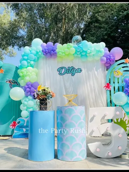 Ditya's 5th birthday was a beautiful mermaid and ocean-themed party. This outdoor setup uses shades of teal, purple, and green, with details like seashells and mermaid tail patterns to create a whimsical underwater world.
