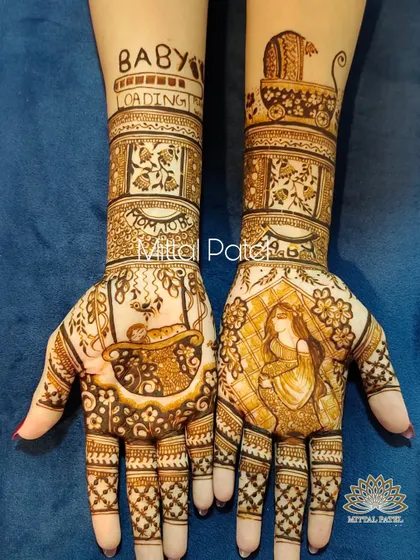 This pregnancy henna design is filled with anticipation. It features a portrait of the mother to be, a baby in a bassinet, and the phrase "Baby Loading" with a progress bar on the forearm.