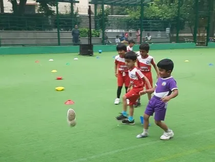 A dynamic action shot of a toddler kicking a ball, capturing the energy of our classes.