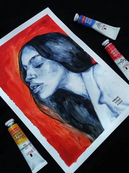 An angled view of my sold blue and red watercolor portrait, highlighting the flow of the hair and the simple color scheme.
