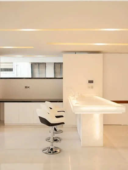 A breakfast counter carved from translucent onyx. The material is backlit to provide a warm glow, making it a functional feature that also serves as a light sculpture.