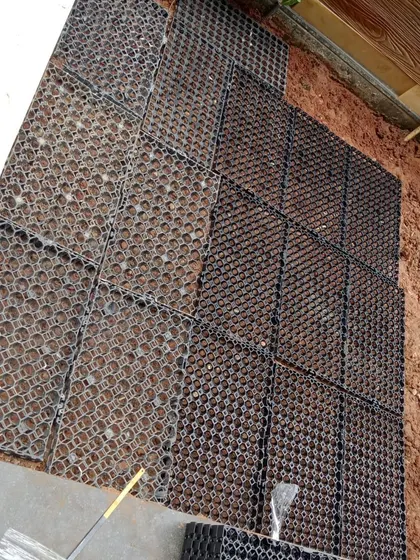 A view of drainage cells being laid on the ground before a lawn installation, a crucial step for ensuring a healthy and long-lasting garden.