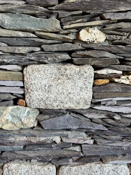 A close-up of a traditional stone wall in Ladakh. The interplay of different sizes, shapes, and colors of stone creates a rich, organic texture that is deeply inspiring.