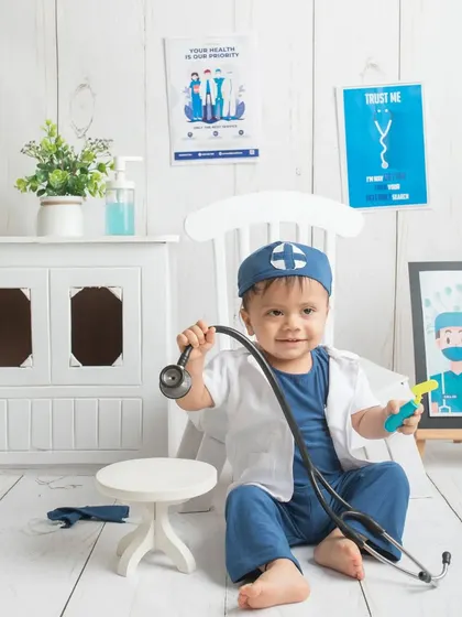 Posing with his medical tools. This themed shoot is a wonderful way to celebrate the profession of his parents and his own playful imagination.